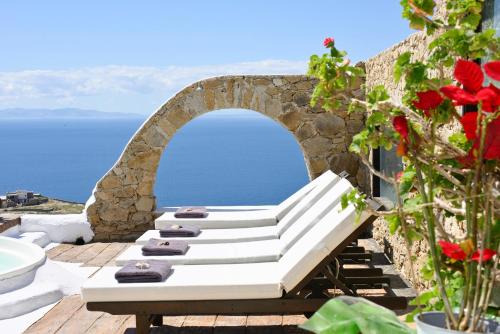 un banco blanco sentado en una terraza con vistas al océano en Villa Fos, en Fanari