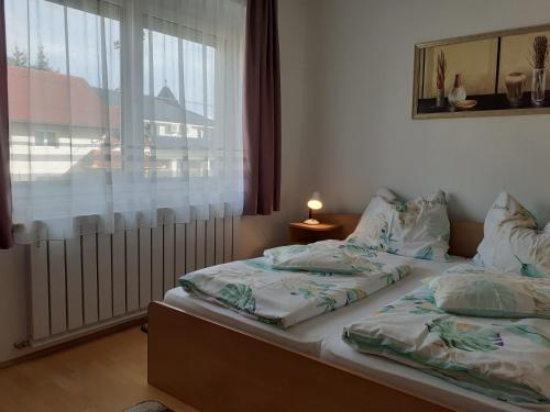 a bedroom with two twin beds and a window at Apartman Venus in Hévíz