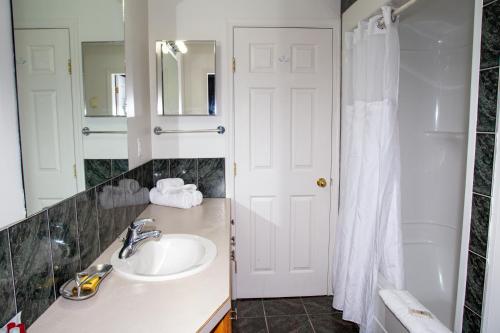a bathroom with a sink and a mirror at Spanish Villa Resort in Penticton