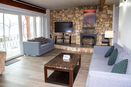 a living room with couches and a stone fireplace at Spanish Villa Resort in Penticton