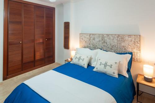 een slaapkamer met een blauw bed met 2 witte kussens bij Ketan Suite Nadales in Málaga