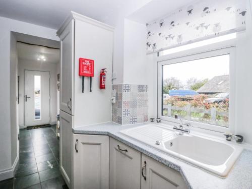 cocina blanca con fregadero y ventana en Station View en Soutergate
