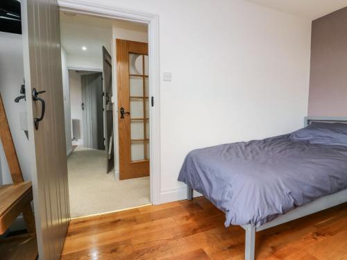 a bedroom with a bed and a door leading to a hallway at Station View in Soutergate