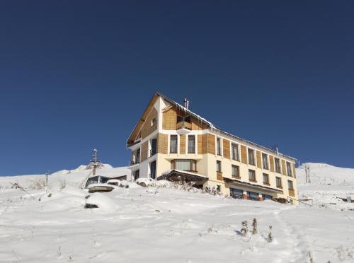 um edifício no topo de uma montanha coberta de neve em RezoHut em Gudauri