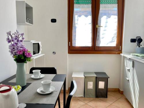 una cocina con una mesa con un jarrón de flores púrpuras en Rome Open City Home en Roma