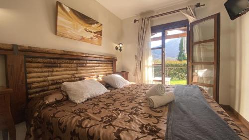 Un dormitorio con una cama grande y una ventana en Apartamentos Rurales Quintana de LLanes, en Llanes