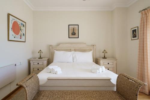 1 dormitorio con 1 cama blanca grande y 2 sillas en Villa White Cottage by SAPvillas, en Vilamoura