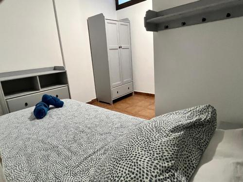 Casa Canleyy في لوس يانوس دي أريداني: غرفة نوم يوجد عليها سرير وحشرة زرقاء