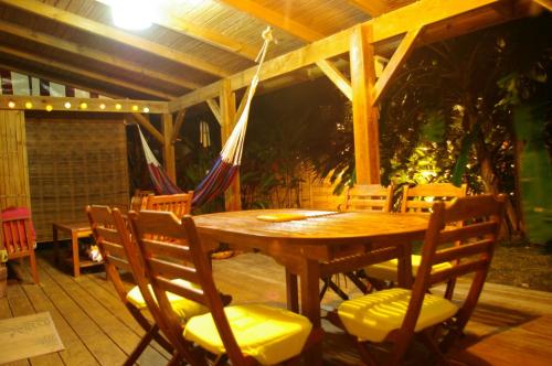 a wooden table and chairs on a patio at Kaz Créole Aventure Tropicale Insolite, Fibre, Jardin et Jacuzzi Privés in Saint-François