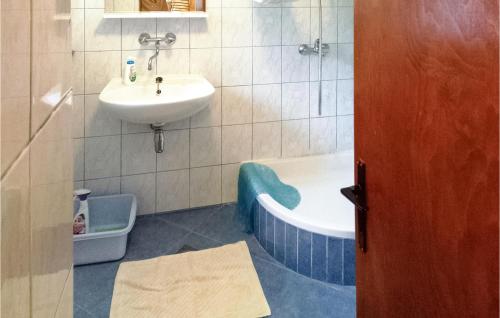 ein Badezimmer mit einem Waschbecken, einer Badewanne und einem Waschbecken in der Unterkunft Awesome Home In Olib With Wifi And 4 Bedrooms in Olib