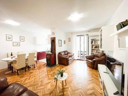 uma sala de estar com mobiliário de couro e uma sala de jantar em Apartman Dorja em Fažana