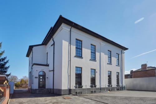 a white building with a black roof at The Ashcroft Apartments - Free Parking in Manchester