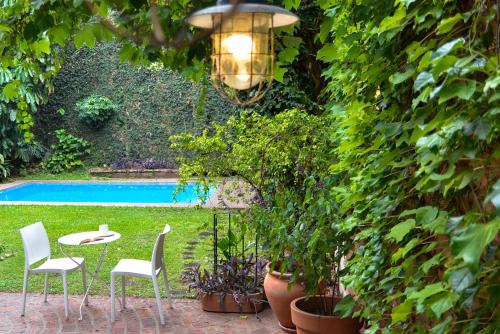 a patio with a table and chairs and a pool at Hostel Posada Juan Ignacio in Rosario