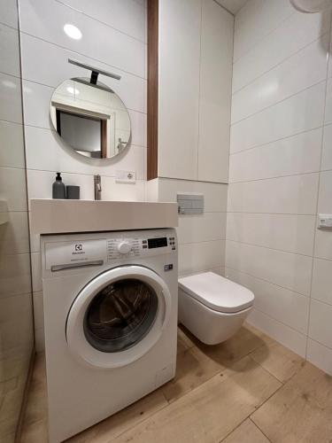 a bathroom with a washing machine and a toilet at Loft на Кониського, центр in Dnipro