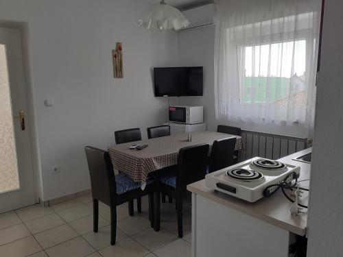 una cucina e una sala da pranzo con tavolo e sedie di Apartman Venus a Hévíz