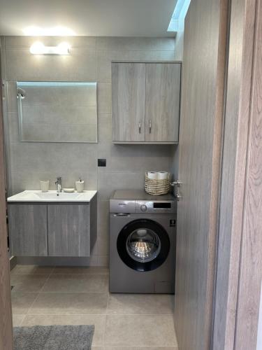 bagno con lavatrice e lavandino di Little Nest - Luxury Living a Città di Kos