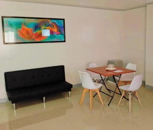 a living room with a table and a black couch at ZM Residence in Dapa
