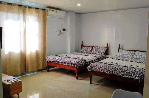 a room with two beds and a window at ZM Residence in Dapa