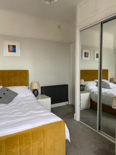 Schlafzimmer mit einem Bett und einem Spiegel in der Unterkunft Central en-suite double room in Plymouth