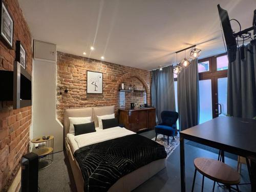 a bedroom with a bed and a brick wall at Apartamenty Prosta - Podmurna in Toruń