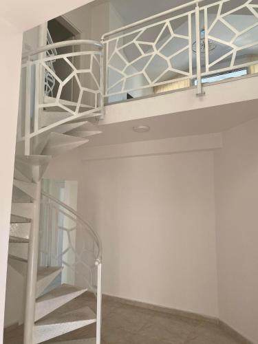 a white bunk bed with a spiral staircase in a room at Villa Jelena in Negotino