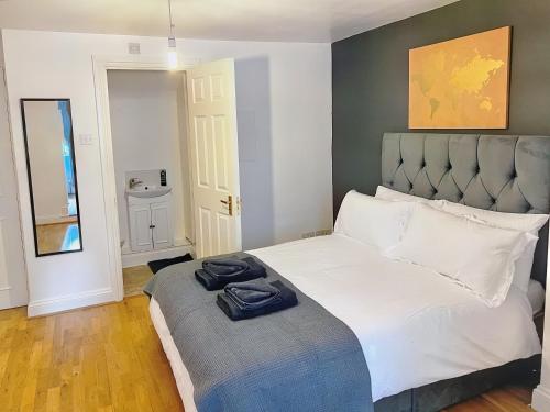 Lovely 2-bedroom serviced apartment Greater London في لندن: غرفة نوم عليها سرير وفوط زرقاء