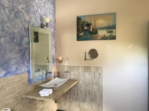 uma casa de banho com um lavatório e um espelho em Real Escondida em Playa del Carmen