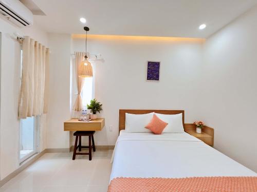 um quarto com uma cama, uma mesa e uma janela em Tuna Hotel Phú Yên em Liên Trì (3)