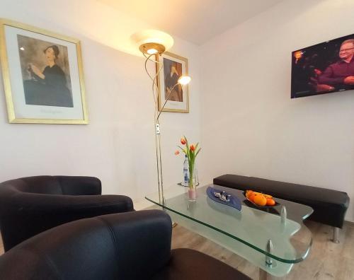 a living room with two chairs and a glass table at Hotel Schloßschenke in Idar-Oberstein