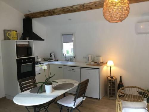 - une cuisine avec une table, une table et des chaises dans l'établissement Studio de charme avec piscine, à Fontaine-de-Vaucluse