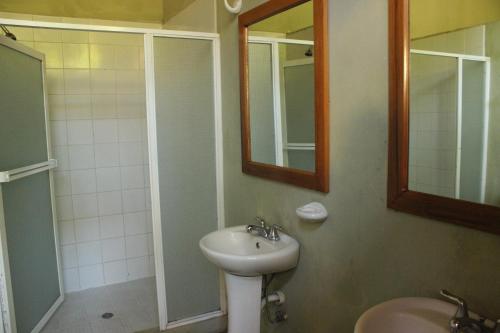 a bathroom with a sink and a mirror and a shower at Backpackers Inn in Granada