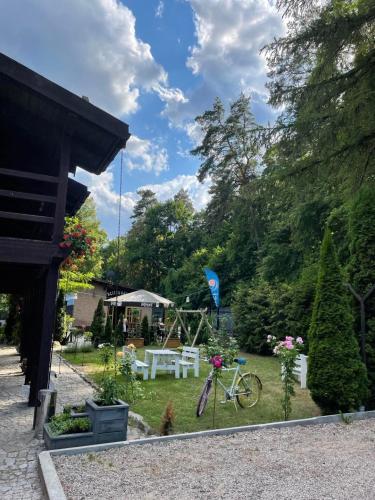 a garden with a picnic table and a bike at Cezar Dom Wczasowy in Ruciane-Nida