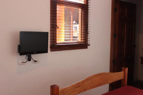 a flat screen tv on a wall next to a window at Hotel Colonial Victonella in Granada