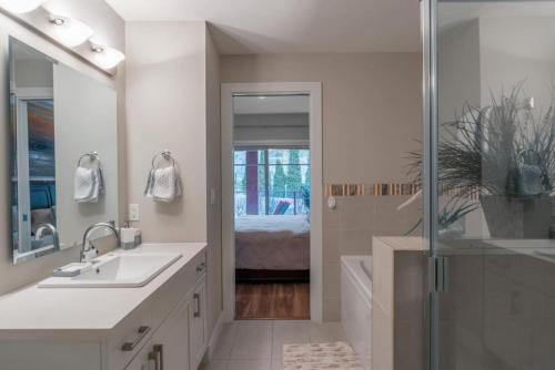 a white bathroom with a sink and a shower at Fabulous Condo at Five Star Resort 209 in West Kelowna