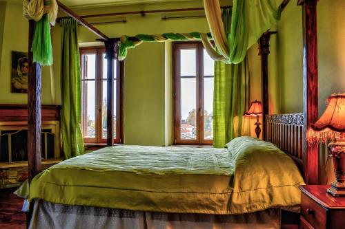 a bedroom with a canopy bed with green walls at Archontiko Polyzos in Portaria