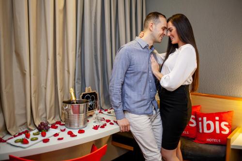 a man and a woman standing next to a table at ibis Criciuma in Criciúma
