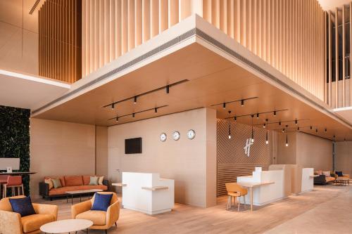 a lobby with chairs and tables and a staircase at Holiday Inn & Suites - Dubai Science Park by IHG in Dubai