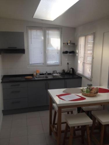 une cuisine avec une table et des chaises et une cuisine avec un évier dans l'établissement Chez Lulu, à Montreuil