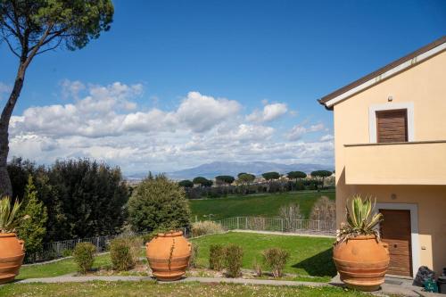 una casa con grandes macetas de plantas en un patio en Tenuta Borsari en Frascati