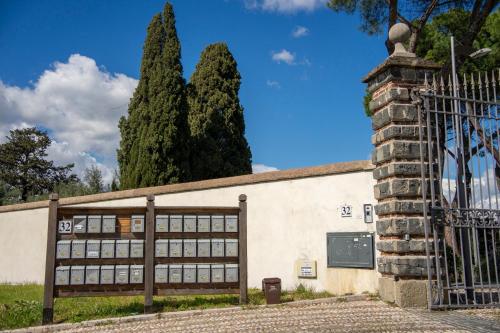 ein Gebäude mit einem Tor und zwei Bäumen in der Unterkunft Tenuta Borsari in Frascati