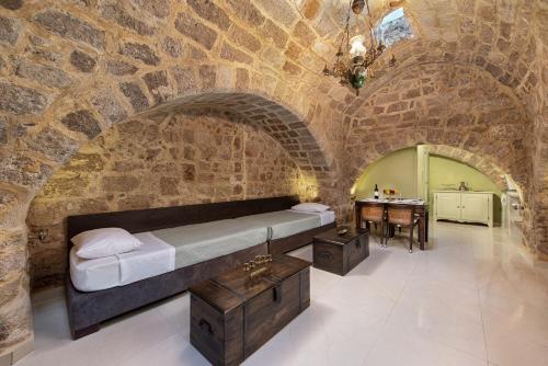 um quarto com uma cama numa parede de pedra em Studio Astero in Ilha de Rhodes