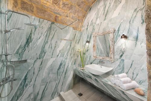 uma casa de banho com um lavatório e um espelho em Studio Astero in Ilha de Rhodes