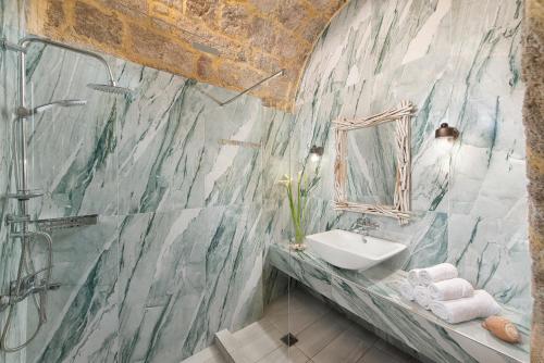 un baño con lavabo y espejo en Studio Astero, en Rodas