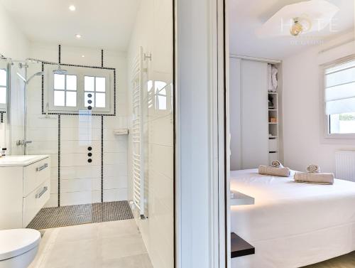 uma casa de banho branca com uma cama e um chuveiro em Les Sables d’Olonne, Villa**** à 250m de la mer em La Chaume