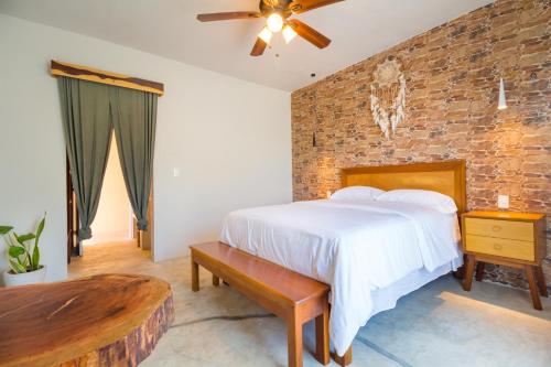 a bedroom with a bed and a brick wall at Jaakbal Tulum in Tulum