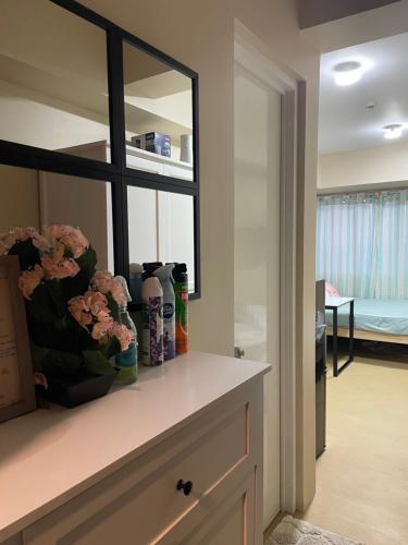 a room with a shelf with vases and flowers on it at Avida Aspira Condominuim Lantaw sa syudad in Cagayan de Oro