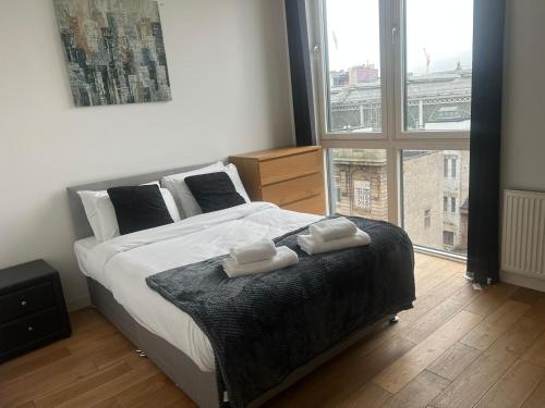 a bedroom with a large bed with two towels on it at Modern 2BD2Bath Apart CityCentre in Glasgow