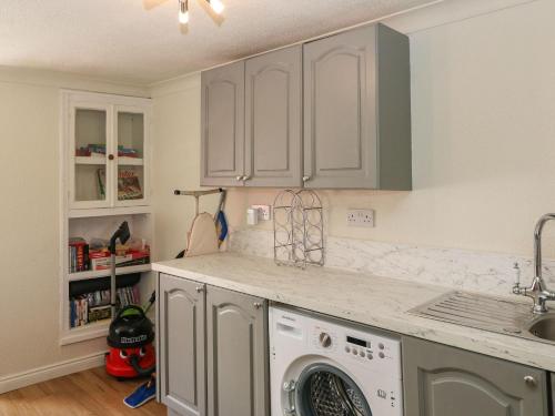 a kitchen with a washing machine and a sink at Shoemaker's Rest in Beara Peninsula
