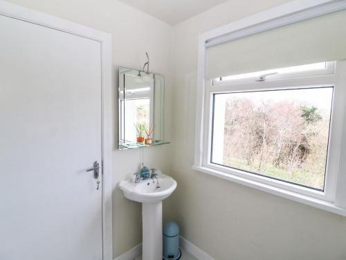a white bathroom with a sink and a window at Shoemaker's Rest in Beara Peninsula