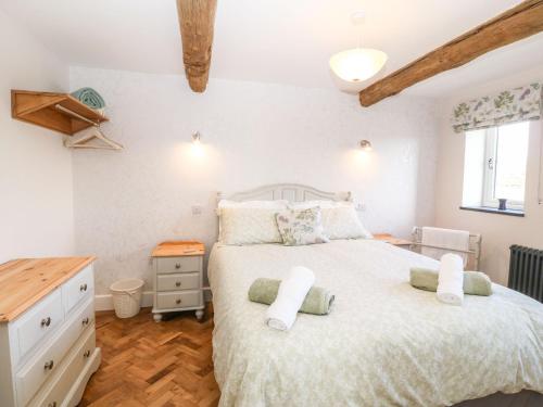 a bedroom with a large bed and a wooden floor at Pip's Barn in Brynteg